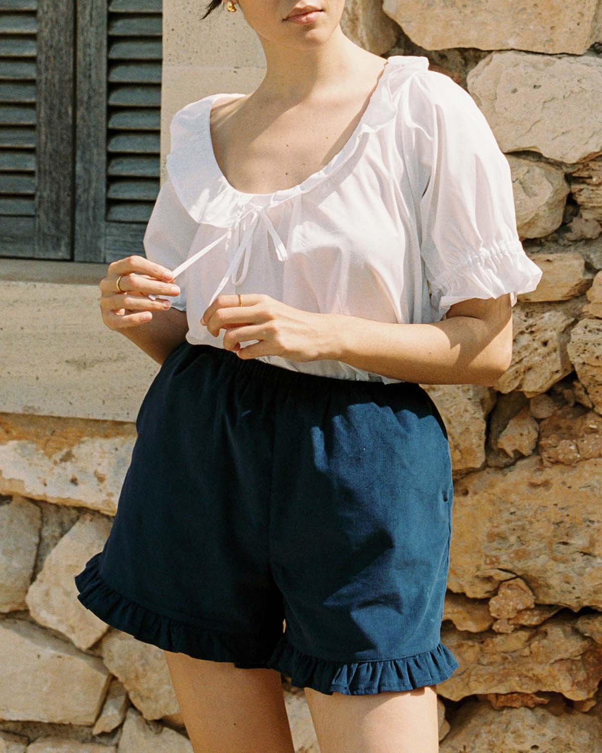 navy micro cord shorts with ruffle hem, pockets, elastic waistband