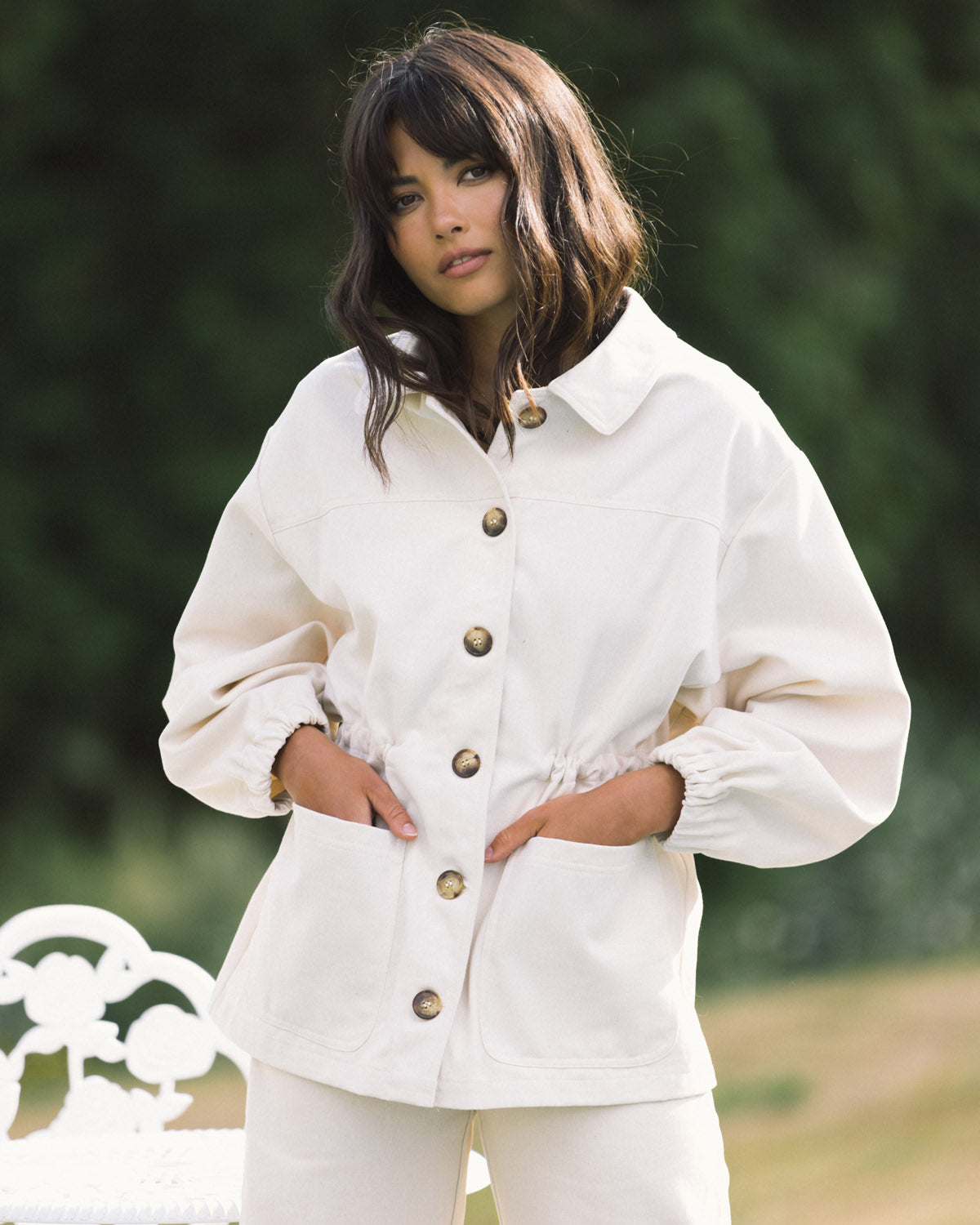 cream-coloured fall jacket with front pockets, cinch waist, and elastic sleeves