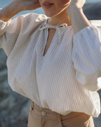 white and blue striped blouse with elastic sleeve cuffs and tie