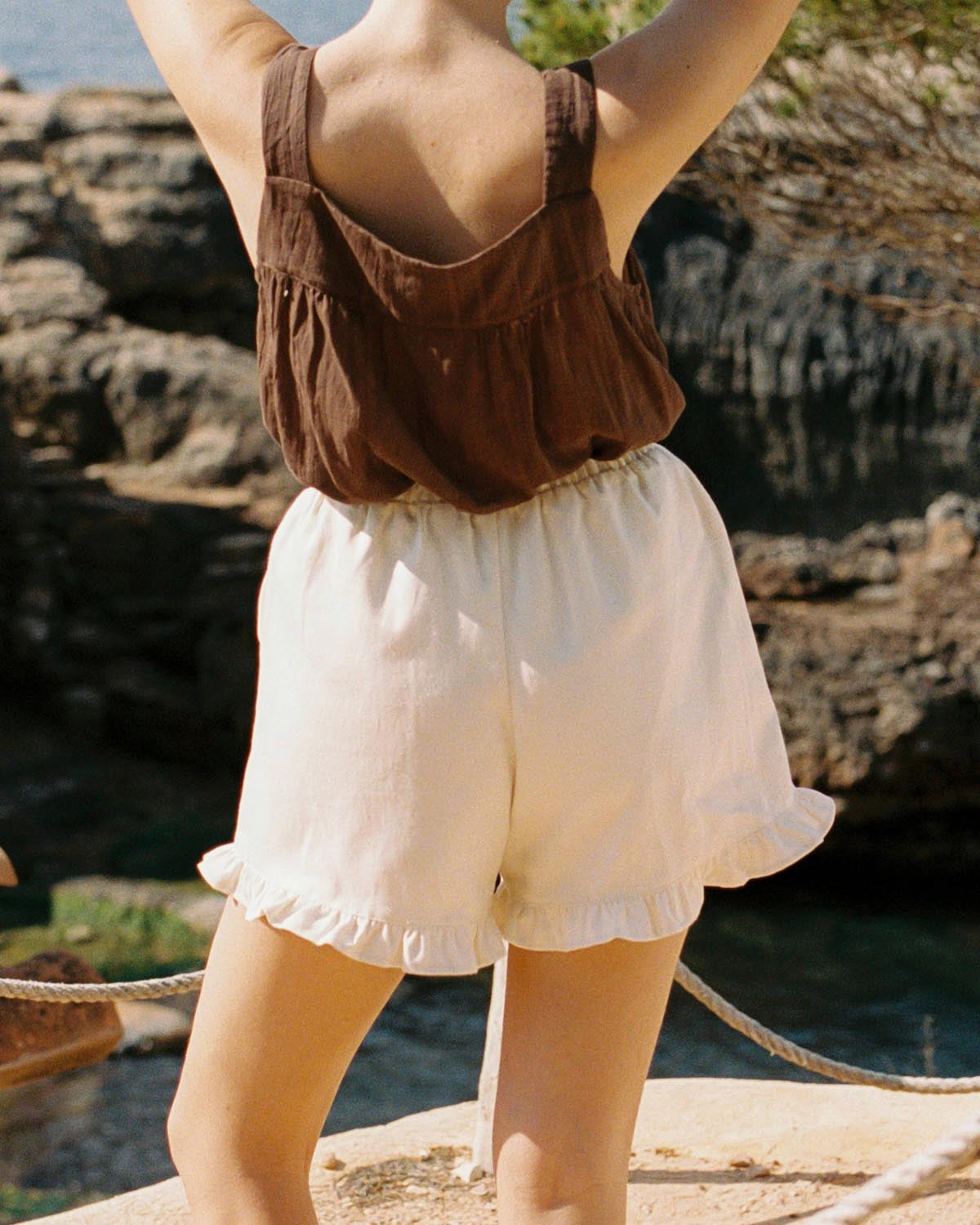 cream shorts with ruffle hem pockets, thin elastic waistband