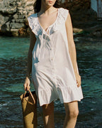 ivory cotton mini dress with ruffle hem, front ties, and button front