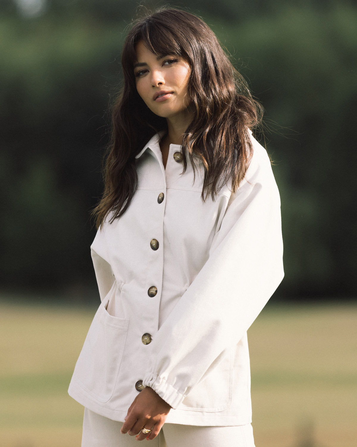 cream-coloured fall jacket with front pockets, cinch waist, and elastic sleeves