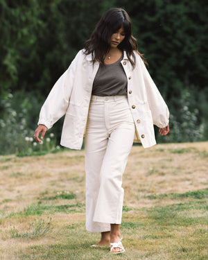 cream-coloured fall jacket with front pockets, cinch waist, and elastic sleeves