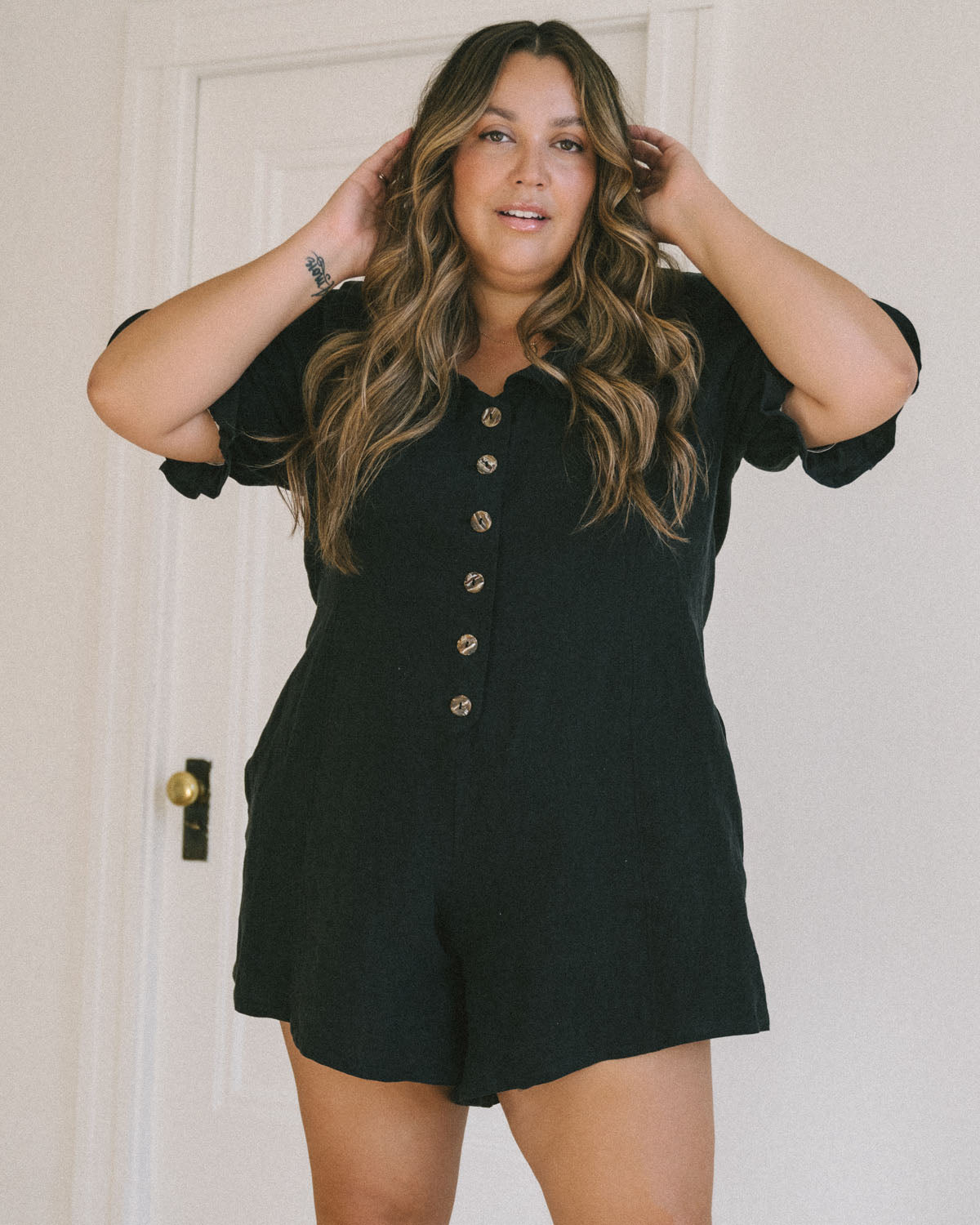 black linen romper with puff sleeves and button front