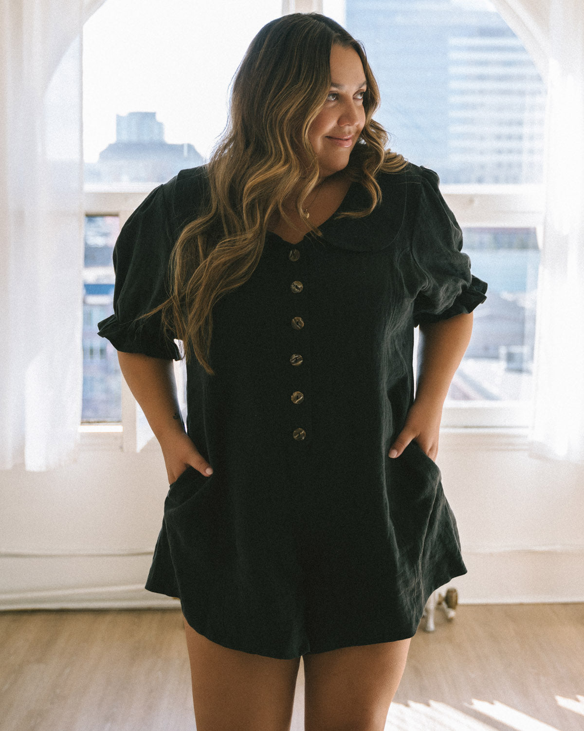 black linen romper with puff sleeves and button front